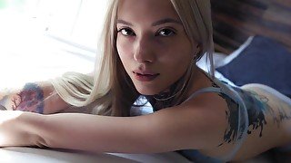 Skinny blonde with tattoos hotly undresses