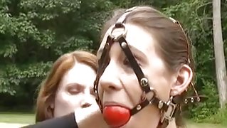 Redhead tortures brunette in public