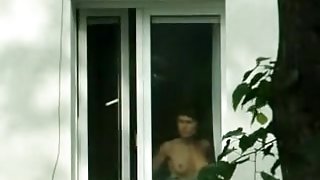 Hot undressed brunette is spied in the window