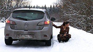 Beautiful slender auburn haired babe pisses behind the car