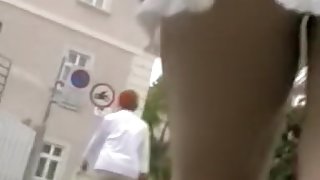 Girl in white knitted dress teasing with erotic upskirt