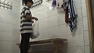 Short brunette white chick undresses in the locker room to wash in the shower