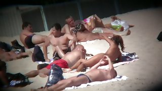 Voyeur on the beach capturing a tanned and naked girl