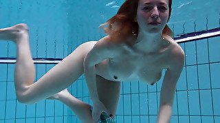 Busty redhead European babe spreads her legs under water