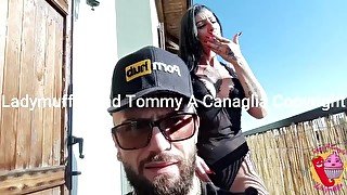 She smokes and he in overalls on the balcony